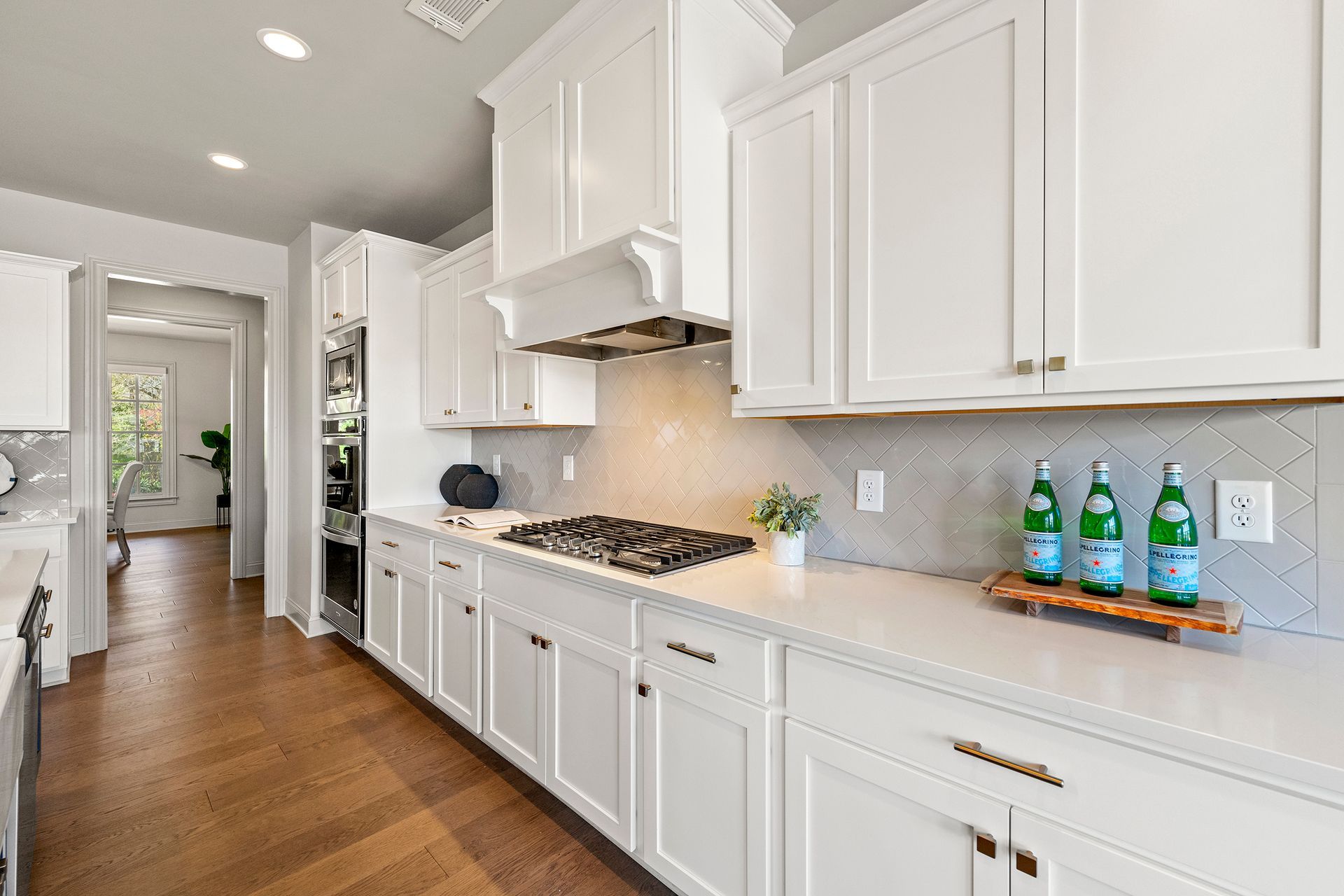 A kitchen with white cabinets and a stove top oven.