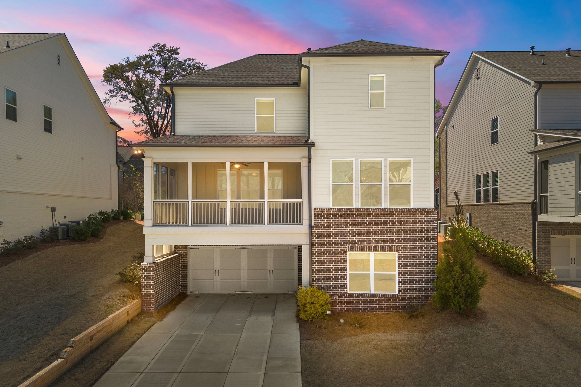 An aerial view of a house with a porch and a garage