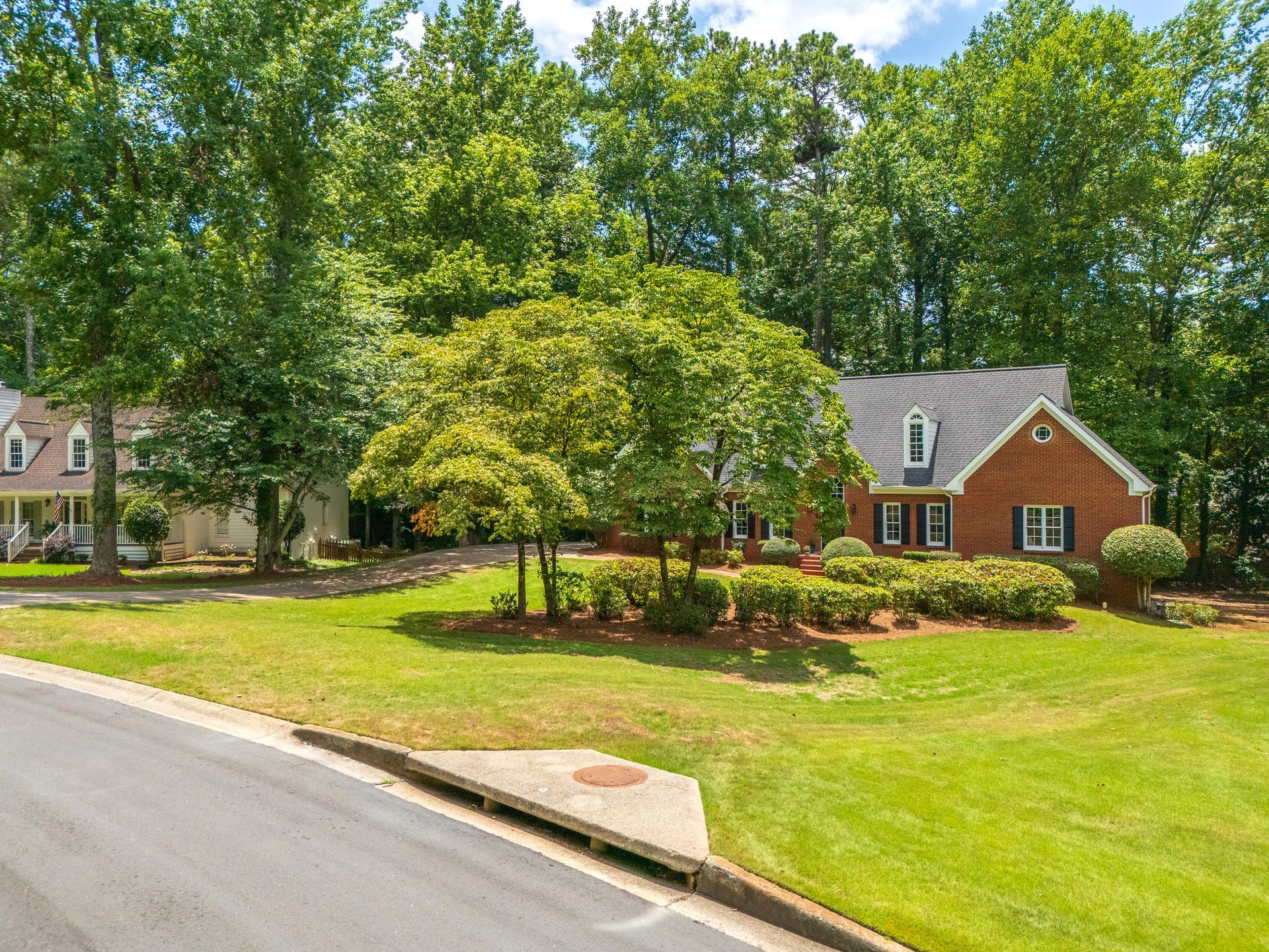 A brick house with a large lawn in front of it