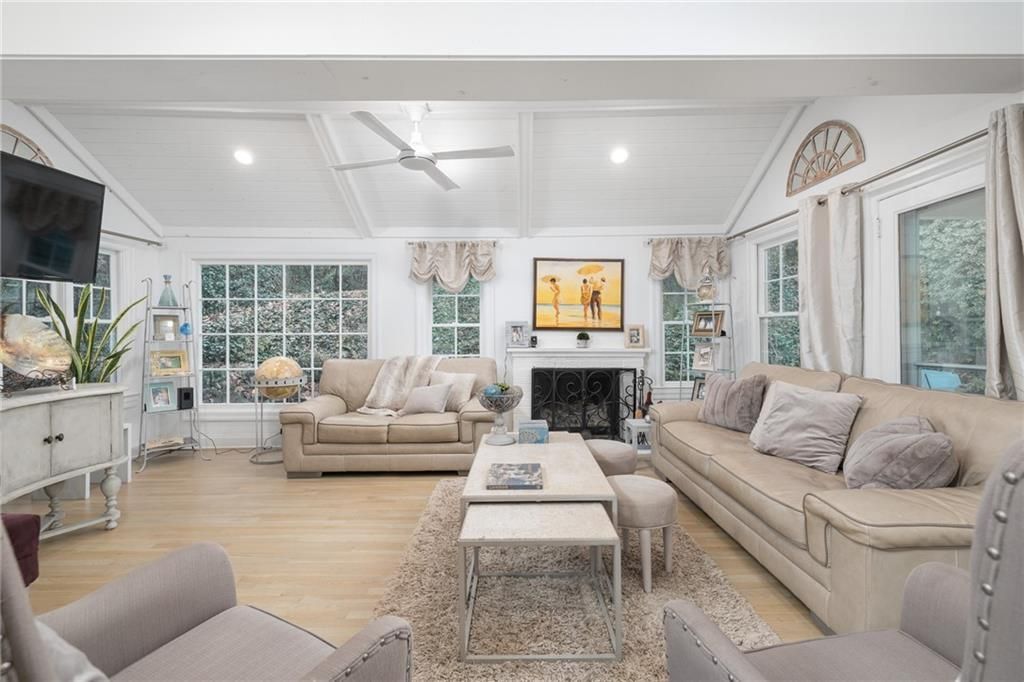 Spacious living room with tan sofas, fireplace, and light wood floors.