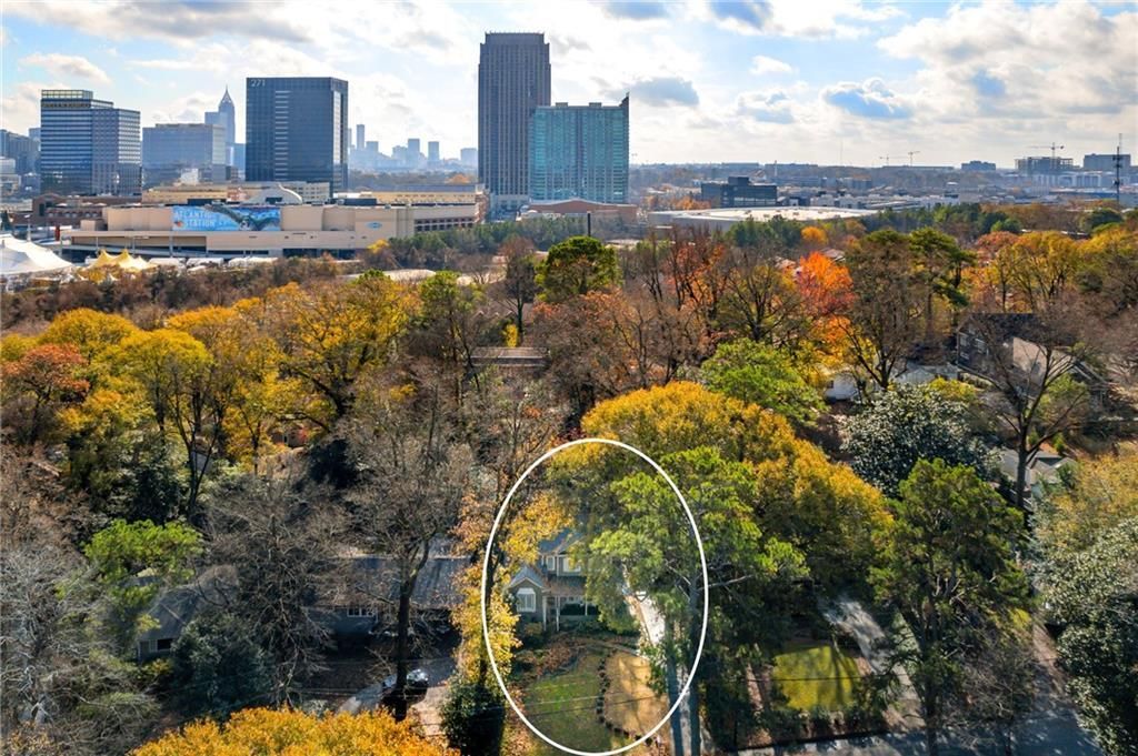 House circled in a landscape of fall foliage with a city skyline in the background.
