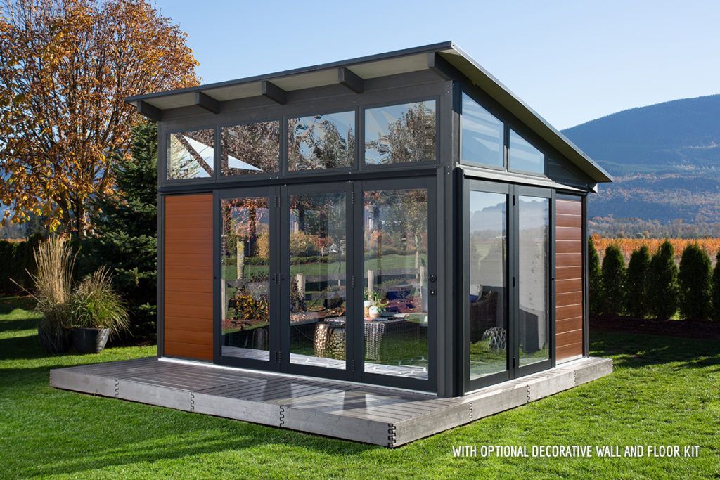 Modern glass and wood sunroom with mountain background.