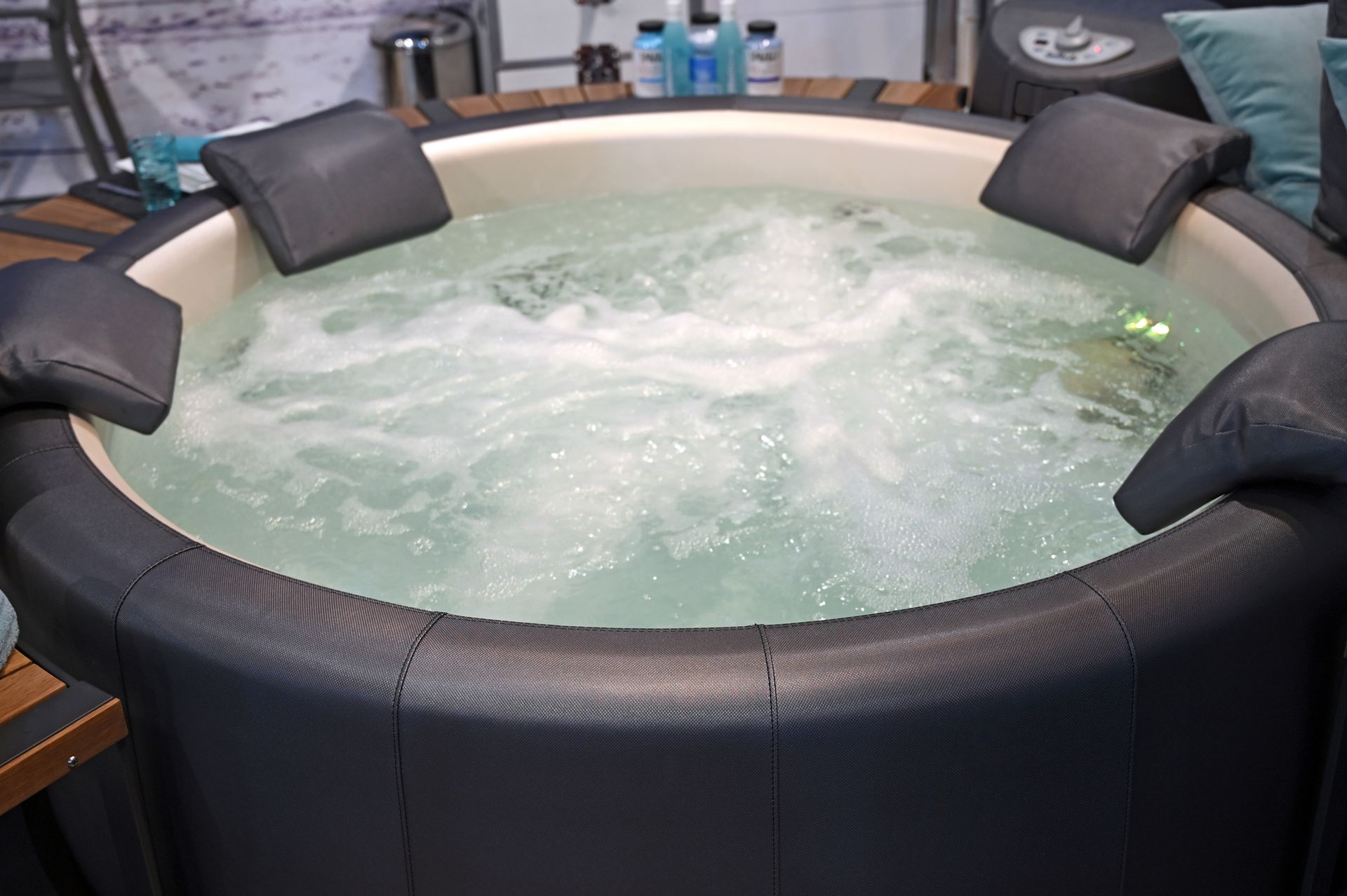 Relaxing round hot tub with bubbling water and padded seats for spa comfort and luxury use.