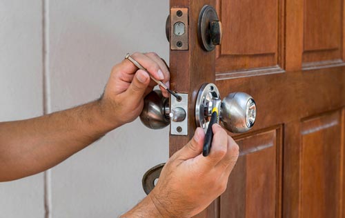 Locks — Man Fixing a Door Lock in South Bend, IN Locks — Man Fixing a Door Lock in South Bend, IN