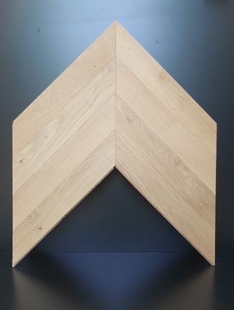 Pezzo di legno con motivo a chevron, di colore beige, dalla forma triangolare, simile a una freccia.