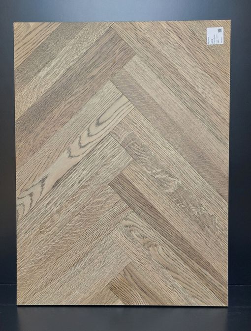 Campione di pavimento in legno con motivo a spina di pesce. Il legno presenta venature marrone chiaro e grigie.