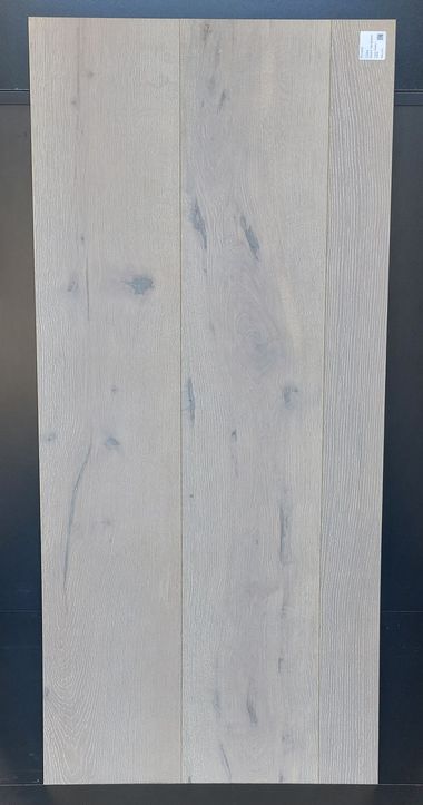 Pavimento in legno grigio chiaro disposto verticalmente. Le venature del legno sono visibili, mostrando la consistenza e le variazioni di colore.