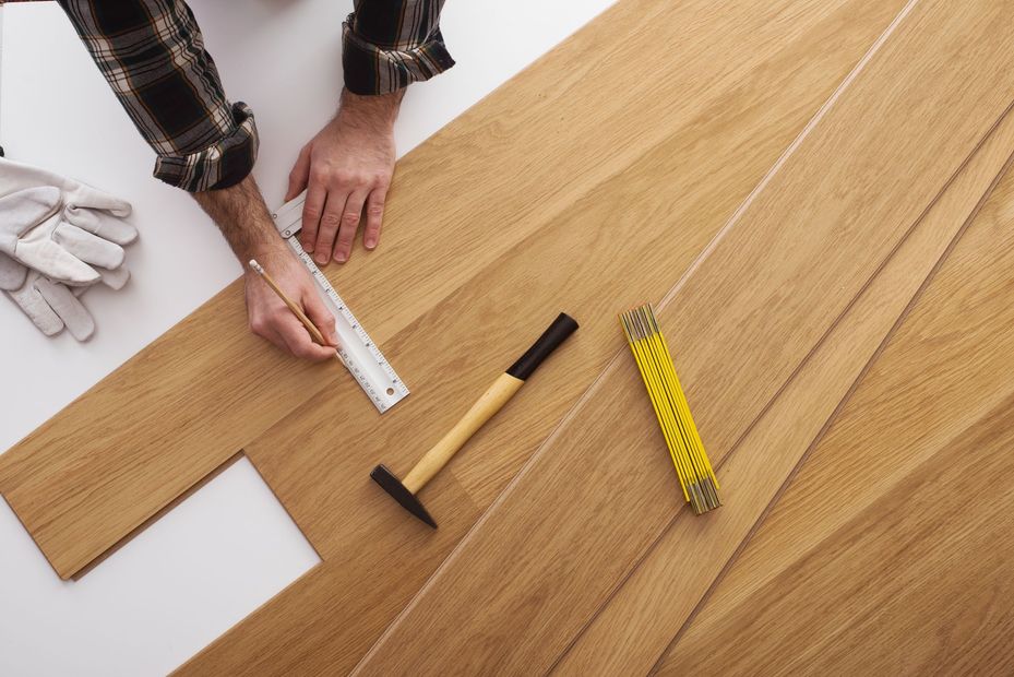 Persona che installa il pavimento in legno.