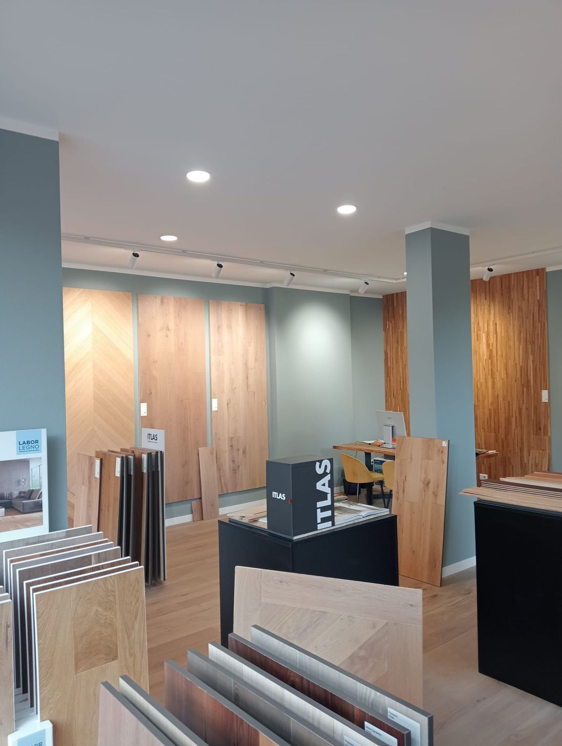 Interno dello showroom di pavimenti con vari campioni di legno in esposizione.