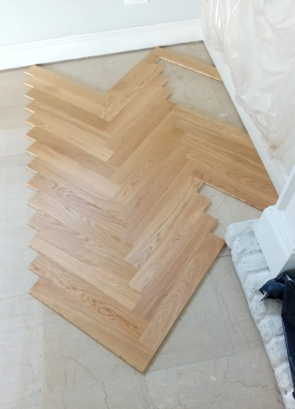 Pavimento in legno massello con motivo a spina di pesce.