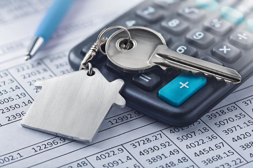 Keys With House-shaped Tag on a Calculator, Over Financial Papers and a Pen — Into Finance Lending Solutions in Nabiac, NSW