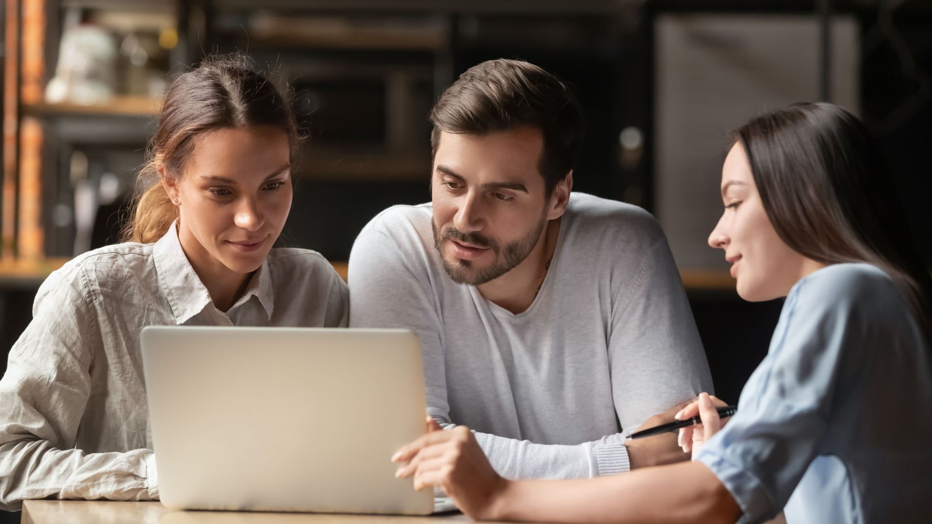 Three People Looking at Laptop Screen, Discussing, Indoors — Into Finance Lending Solutions in Coomba Bay, NSW