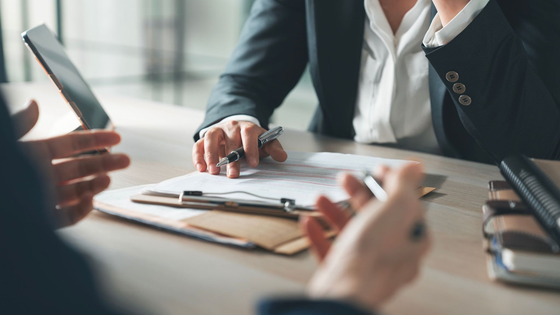 Two People at a Desk, Looking at Documents — Into Finance Lending Solutions in Coomba Bay, NSW