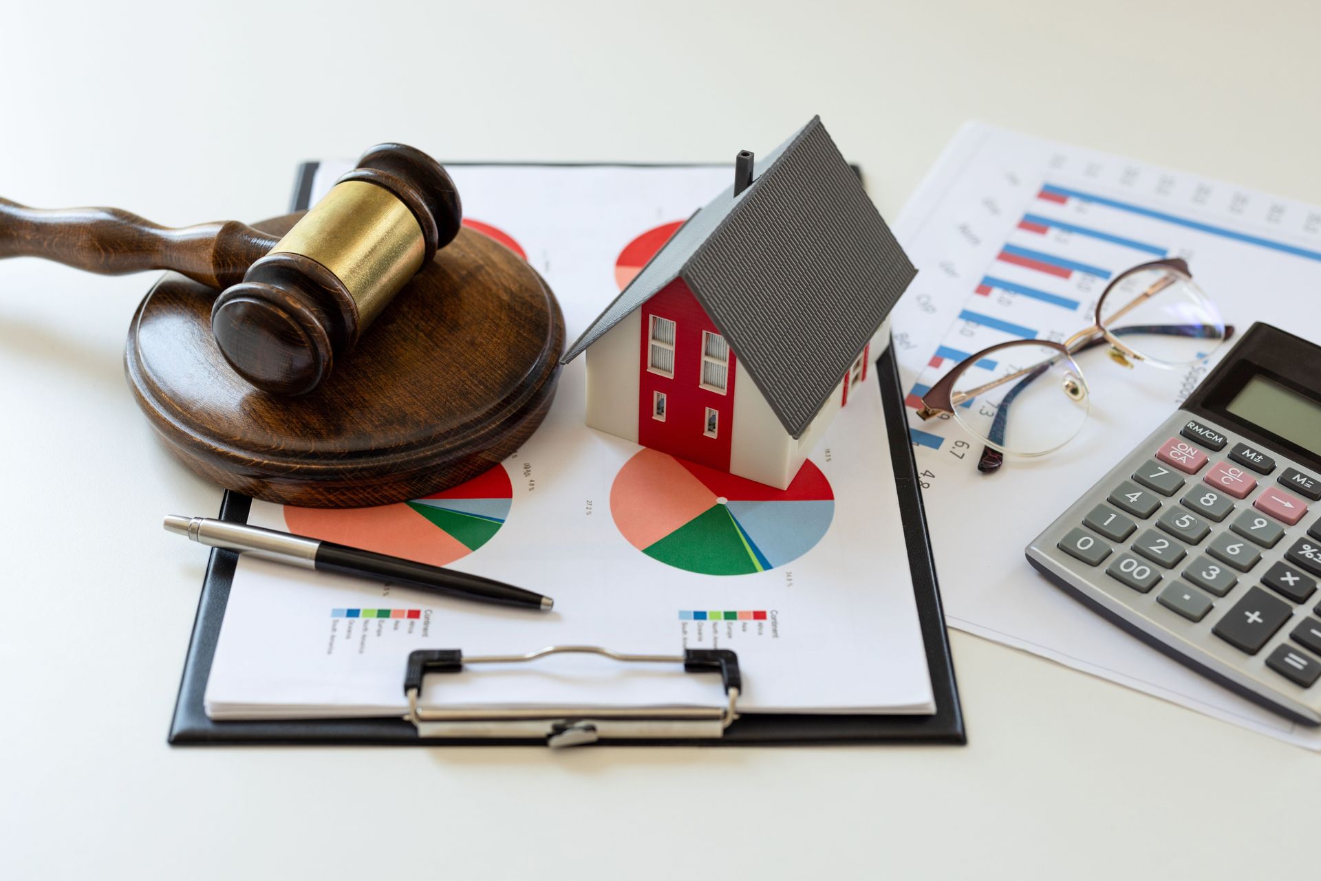 Gavel, Toy House, Charts, Calculator, Pen, and Glasses on a Clipboard — Into Finance Lending Solutions in Coomba Bay, NSW