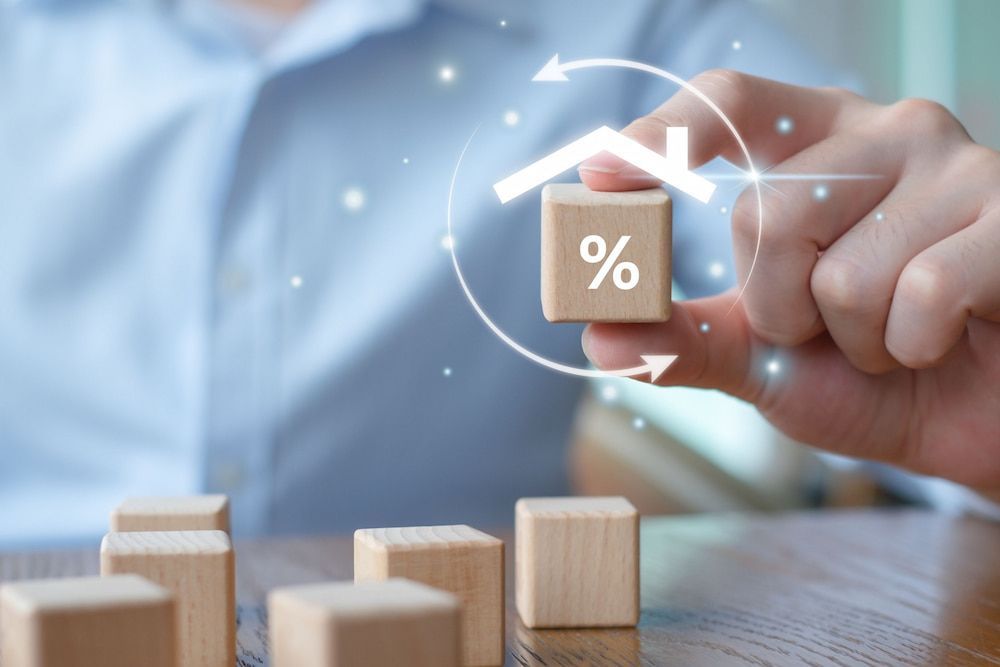 Hand Holding Block With Percentage Symbol Under a House Icon — Into Finance Lending Solutions in Coomba Bay, NSW