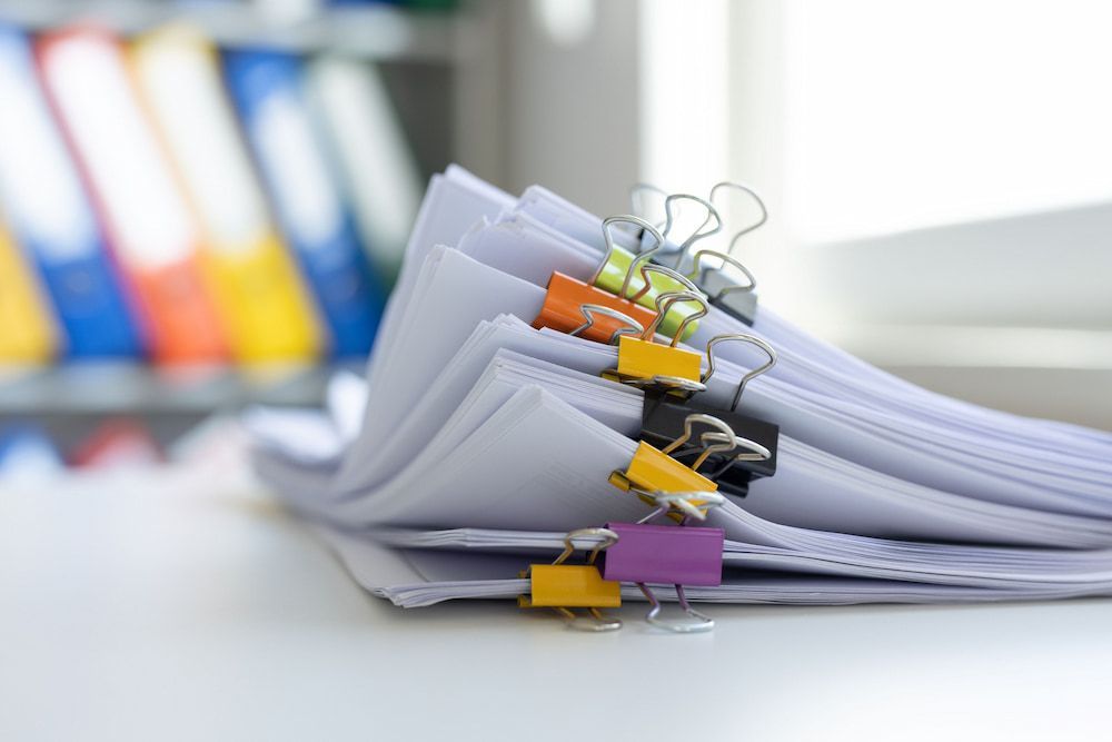 Stack of White Papers Held Together With Colourful Binder Clips — Into Finance Lending Solutions in Harrington, NSW