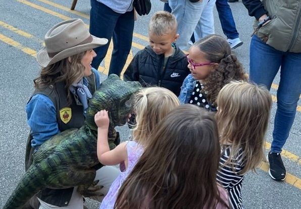 Dinosaur meets children at a street fair