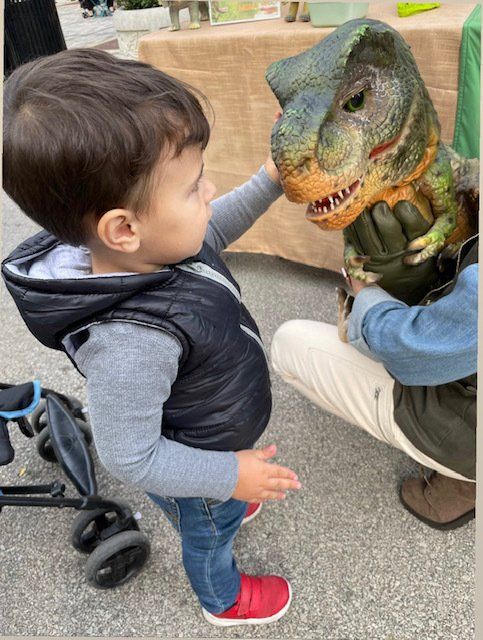 Baby dinosaur receives pets from child