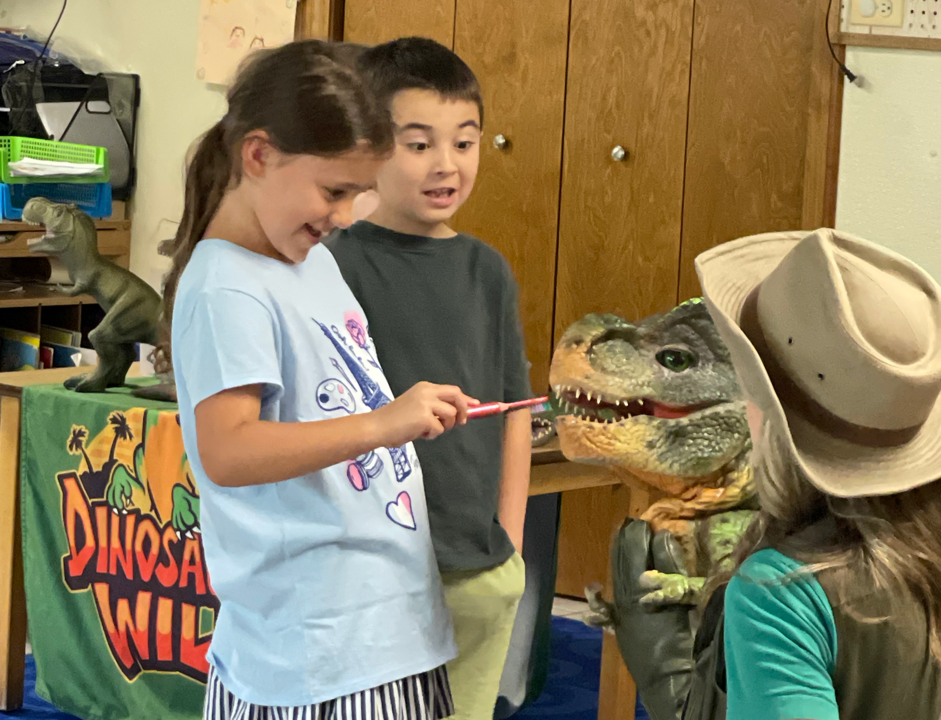 Girl scratches baby dinosaur's chin