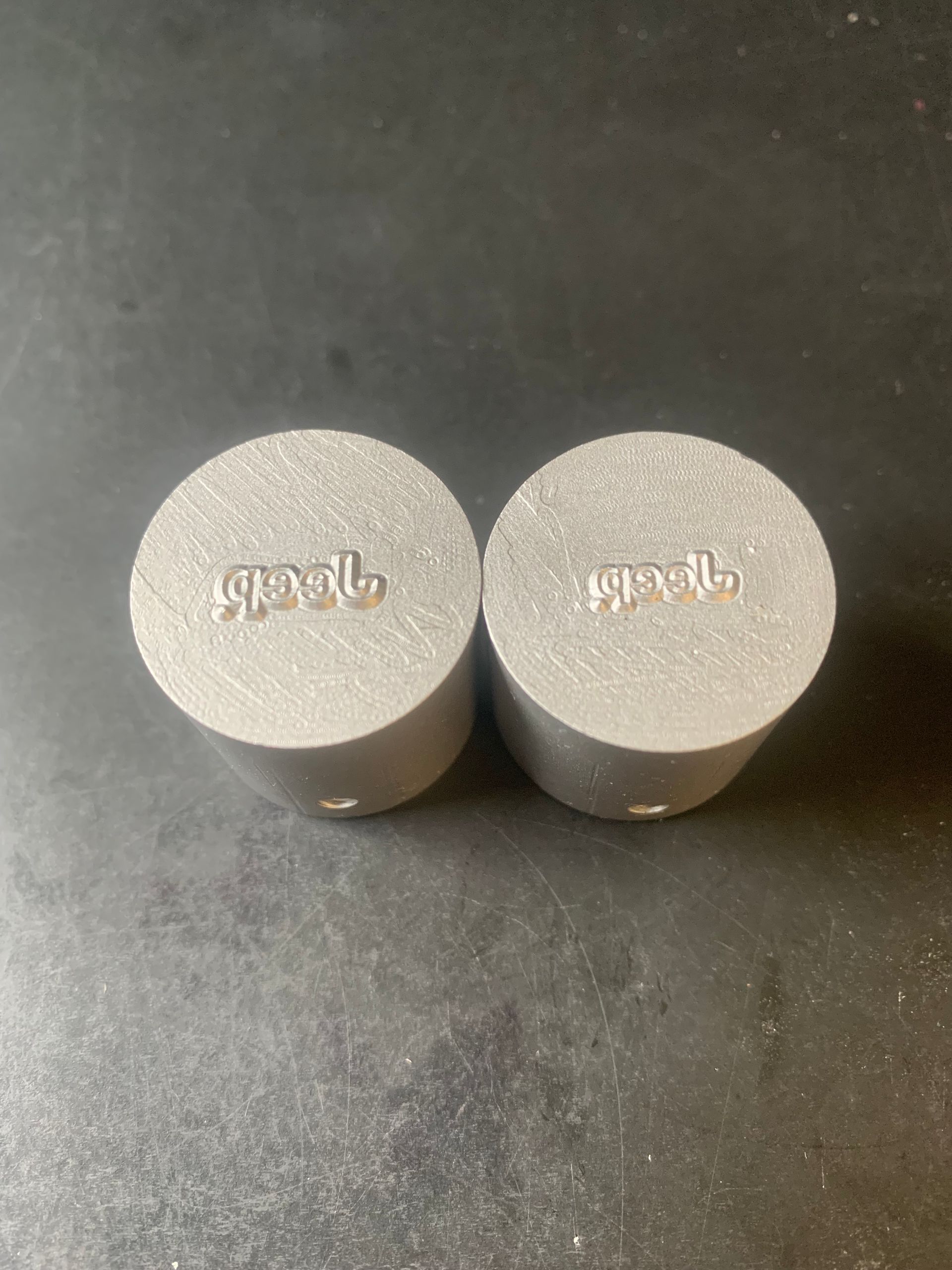 Two gray cylindrical objects with the word 