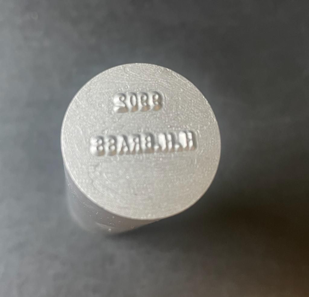 A metal stamp with the imprinted text 