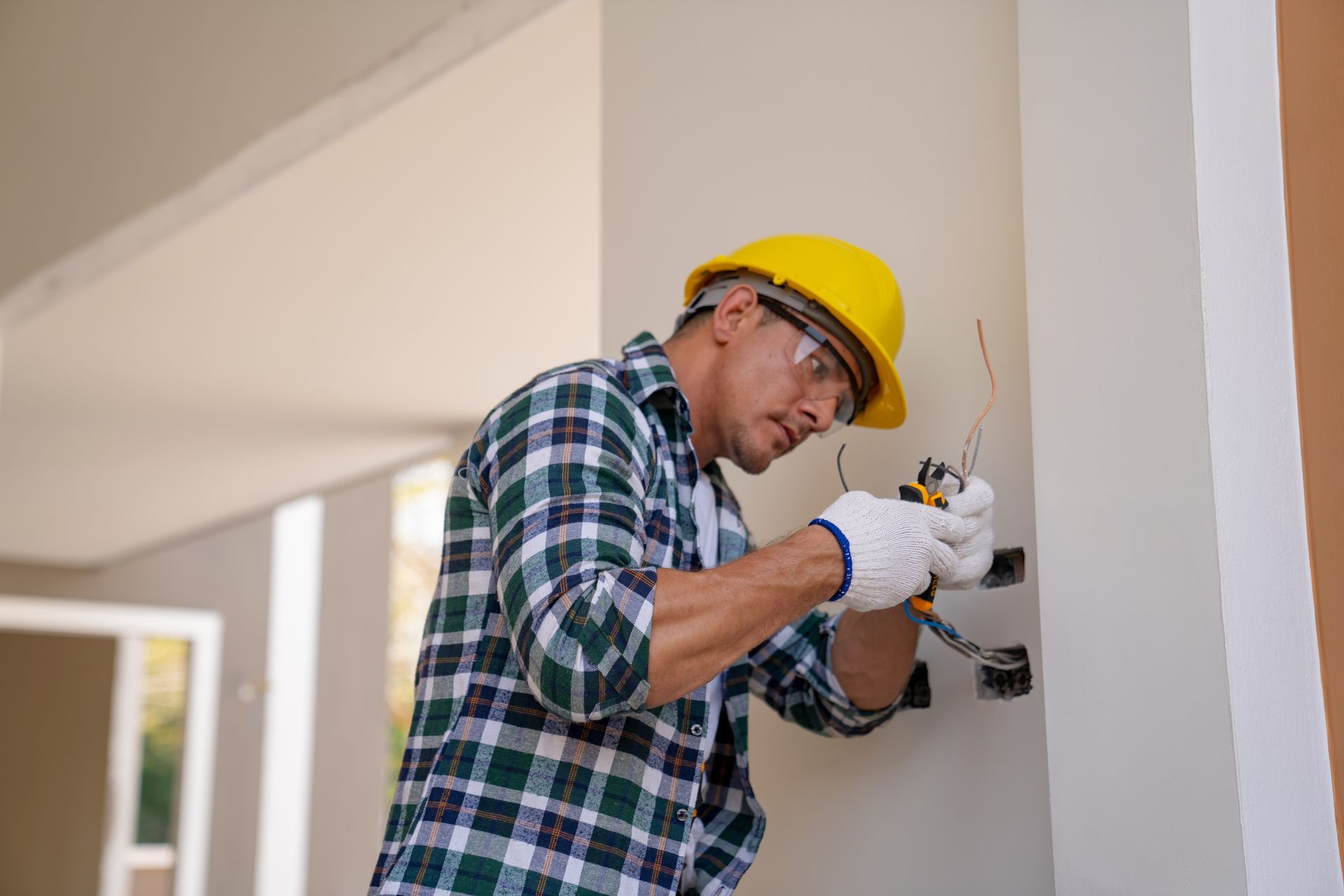 Professional electrician installing apartment electrical wiring.