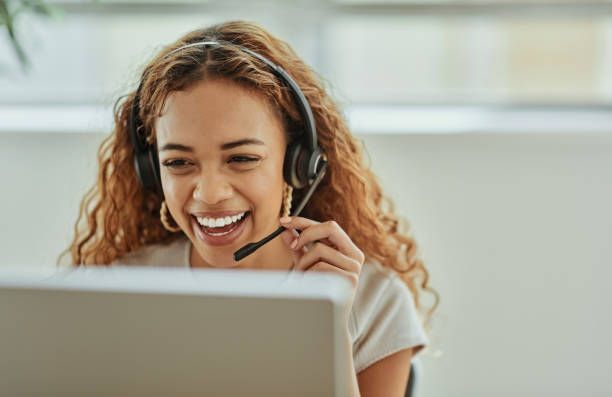 A woman wearing a headset is sitting in front of a laptop computer. - Plymouth, MN - Legacy Pro
