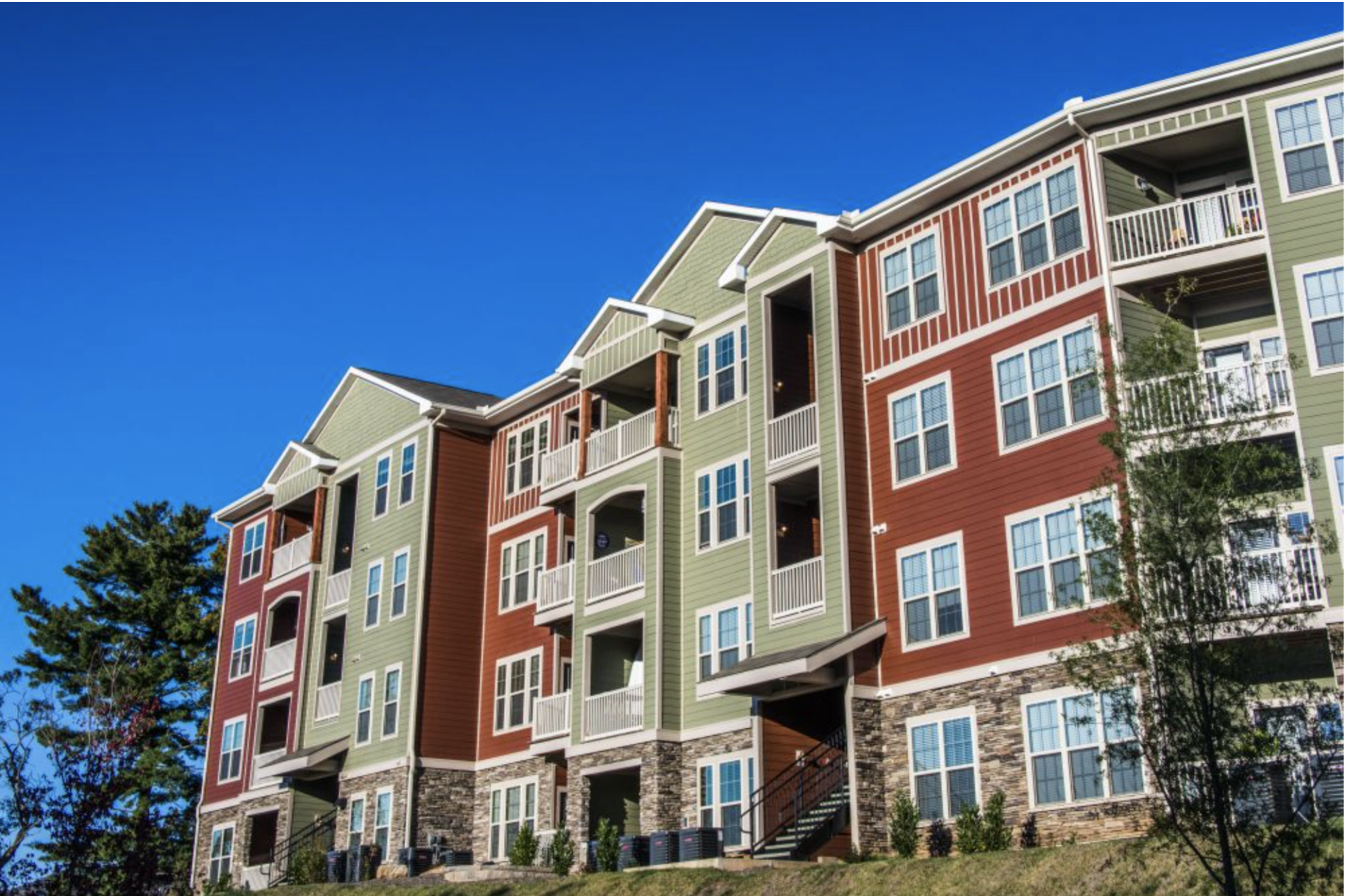 A large apartment building with a blue sky in the background  at Retreat at Hunt Hill