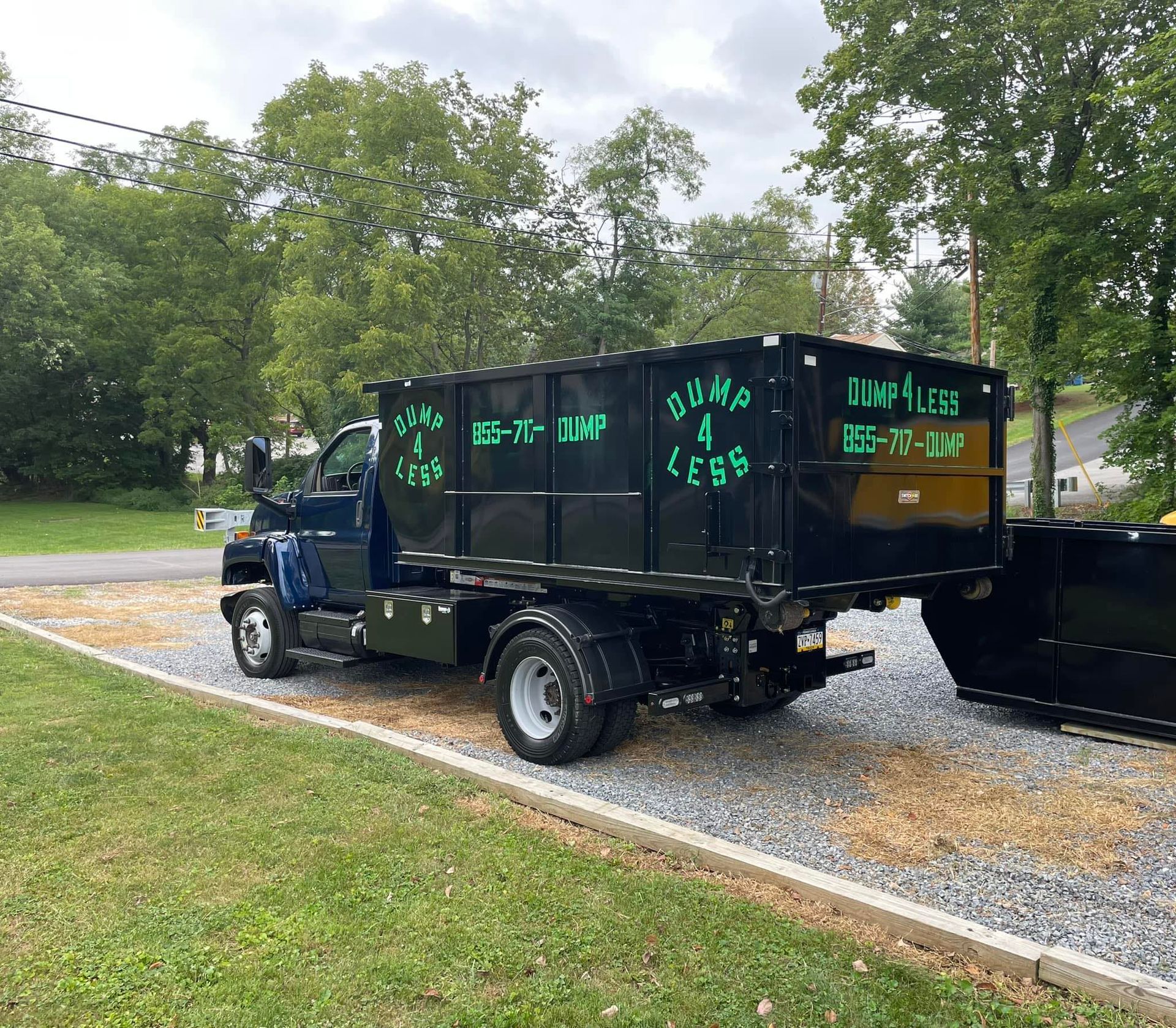 a dump 4 less truck is parked on the side of the road