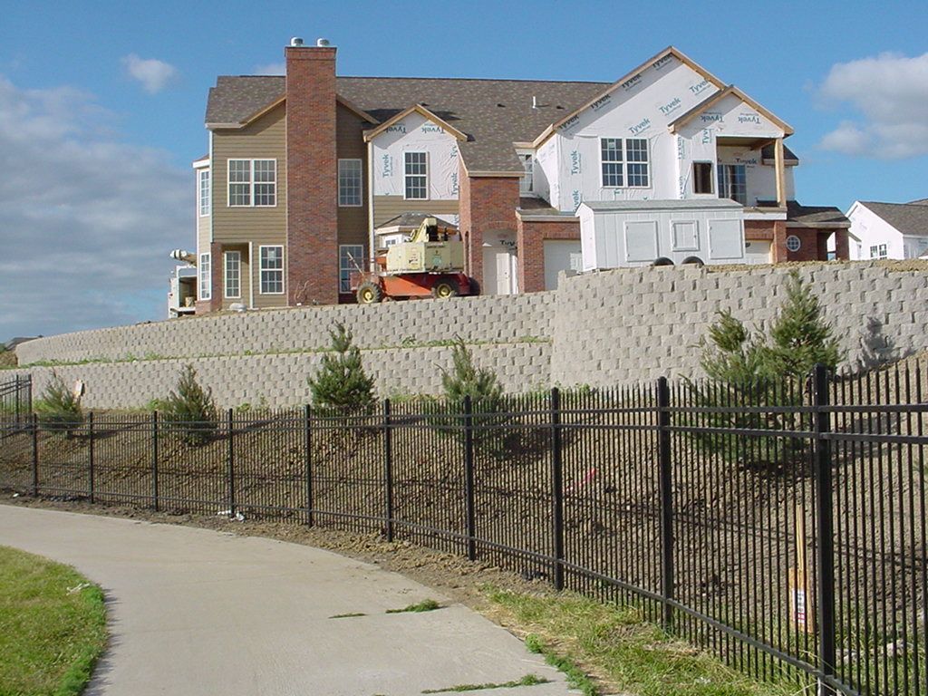 A retaining wall with houses under construction.
