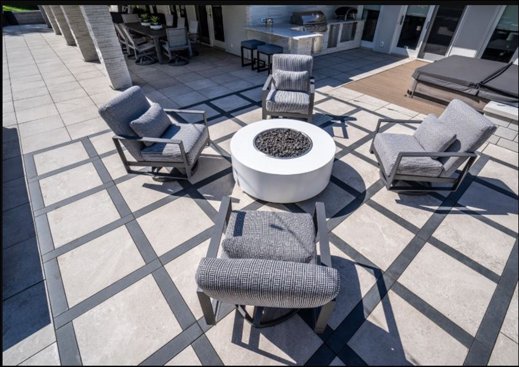 A cozy patio featuring several chairs arranged around a central fire pit.