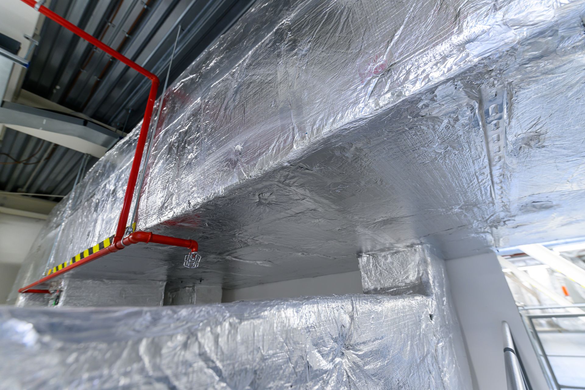 The ceiling of a building is covered in aluminum foil.