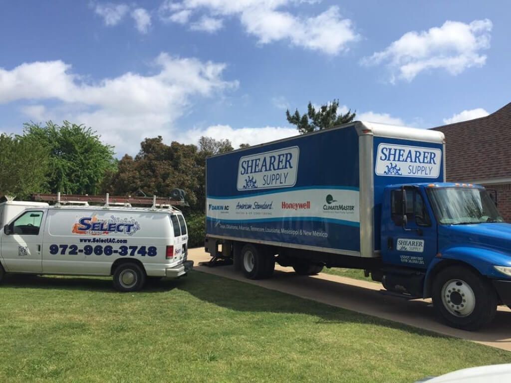 Two shearer moving trucks are parked next to each other in a driveway.