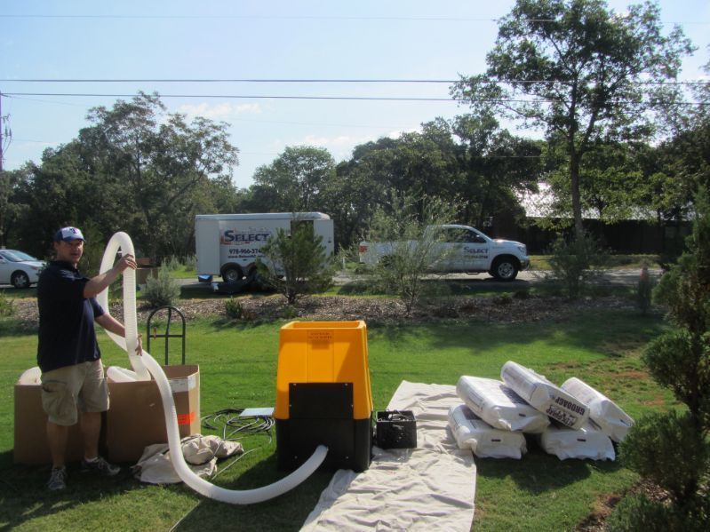 A man is holding a hose in front of a stuart truck