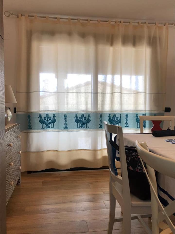 Una sala da pranzo con tavolo e sedie e una grande finestra.