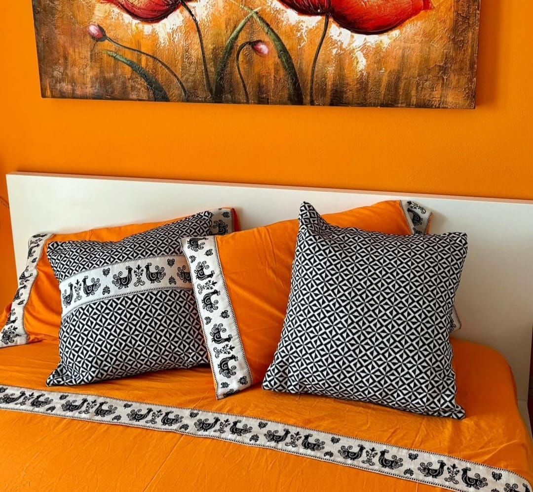 Un letto con cuscini e un dipinto sulla parete sopra di esso