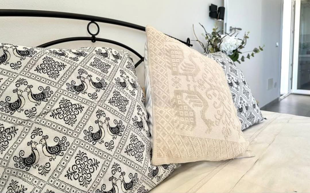 Un letto con un piumone bianco e nero e dei cuscini.