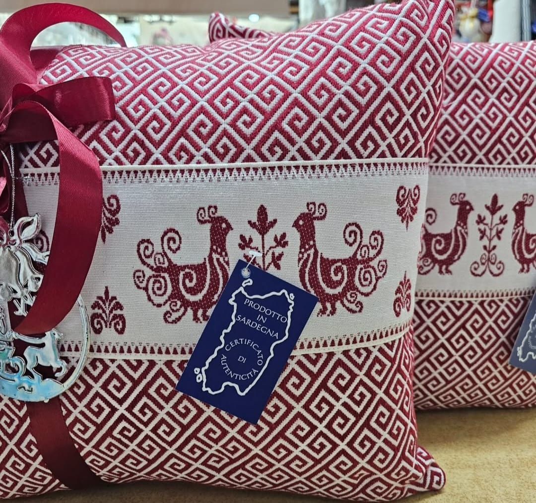 Un cuscino rosso e bianco con un'etichetta che dice