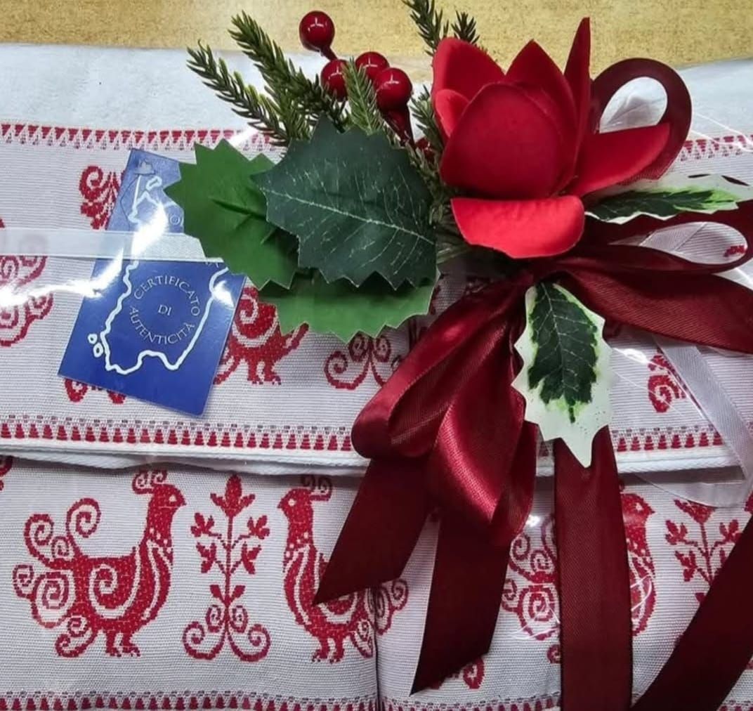 Un fiore rosso è legato a un nastro rosso su una tovaglia