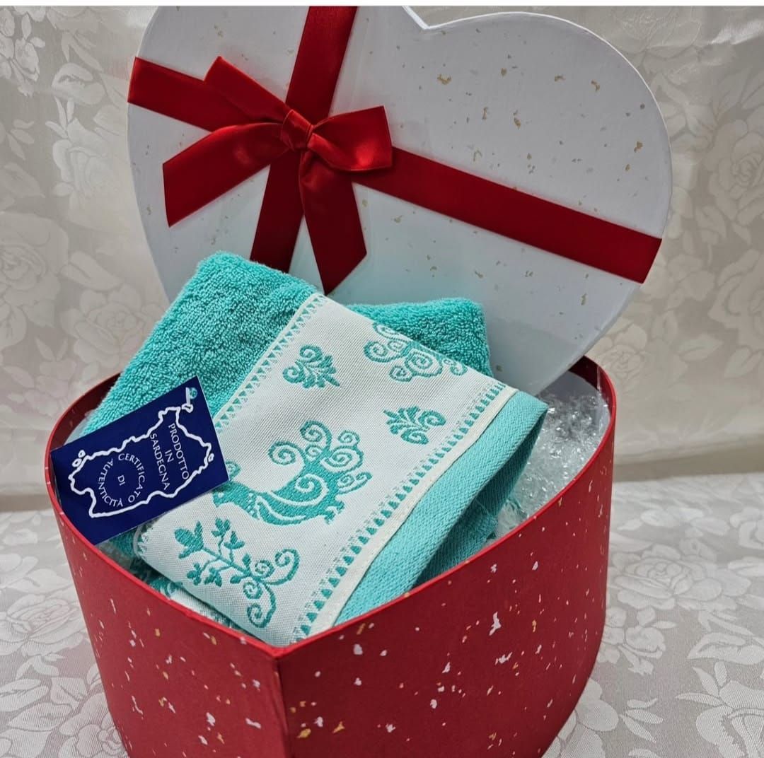 Una scatola a forma di cuore con due asciugamani dentro