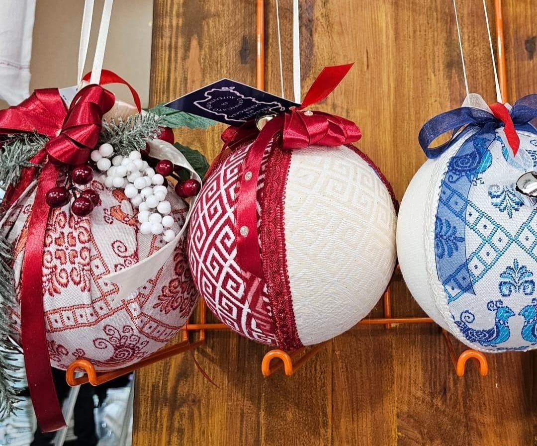 Tre decorazioni natalizie sono appese a una parete di legno.