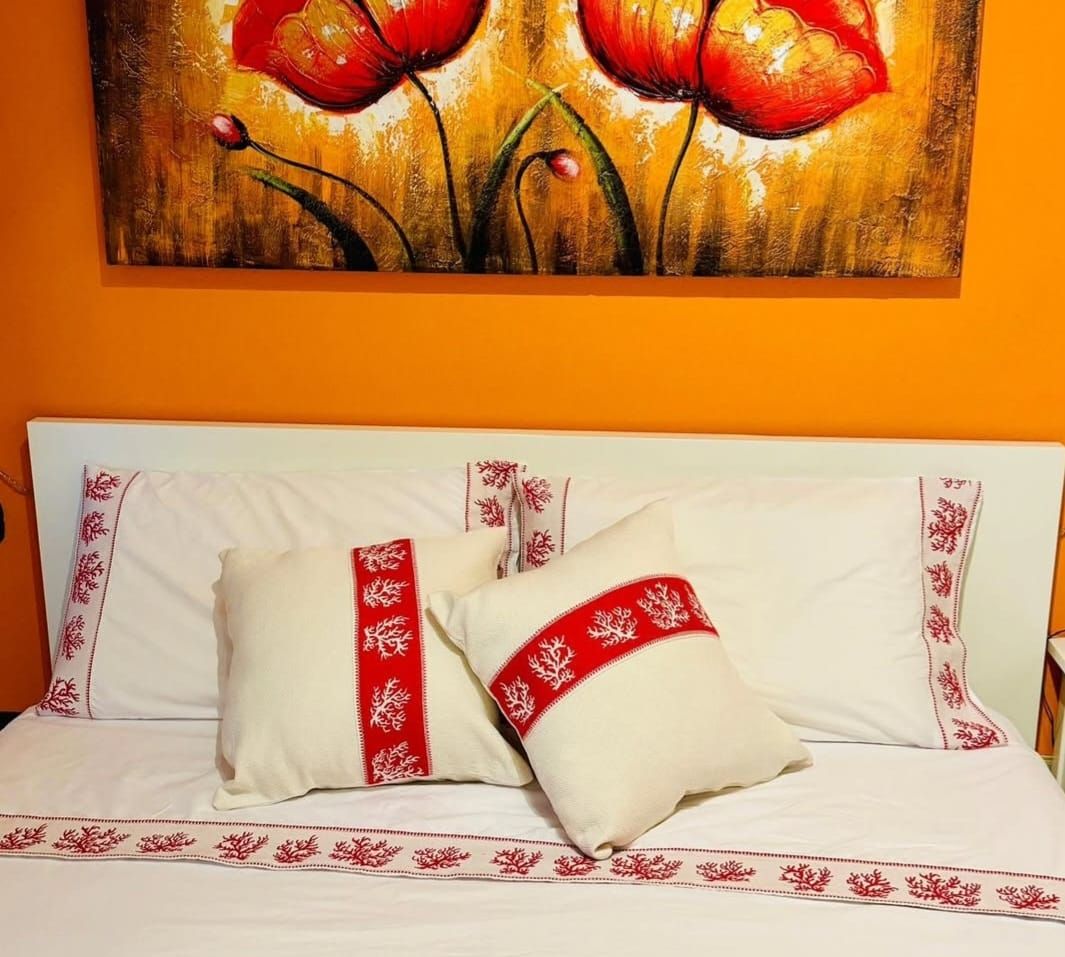 Un letto con cuscini e un dipinto sulla parete sopra di esso