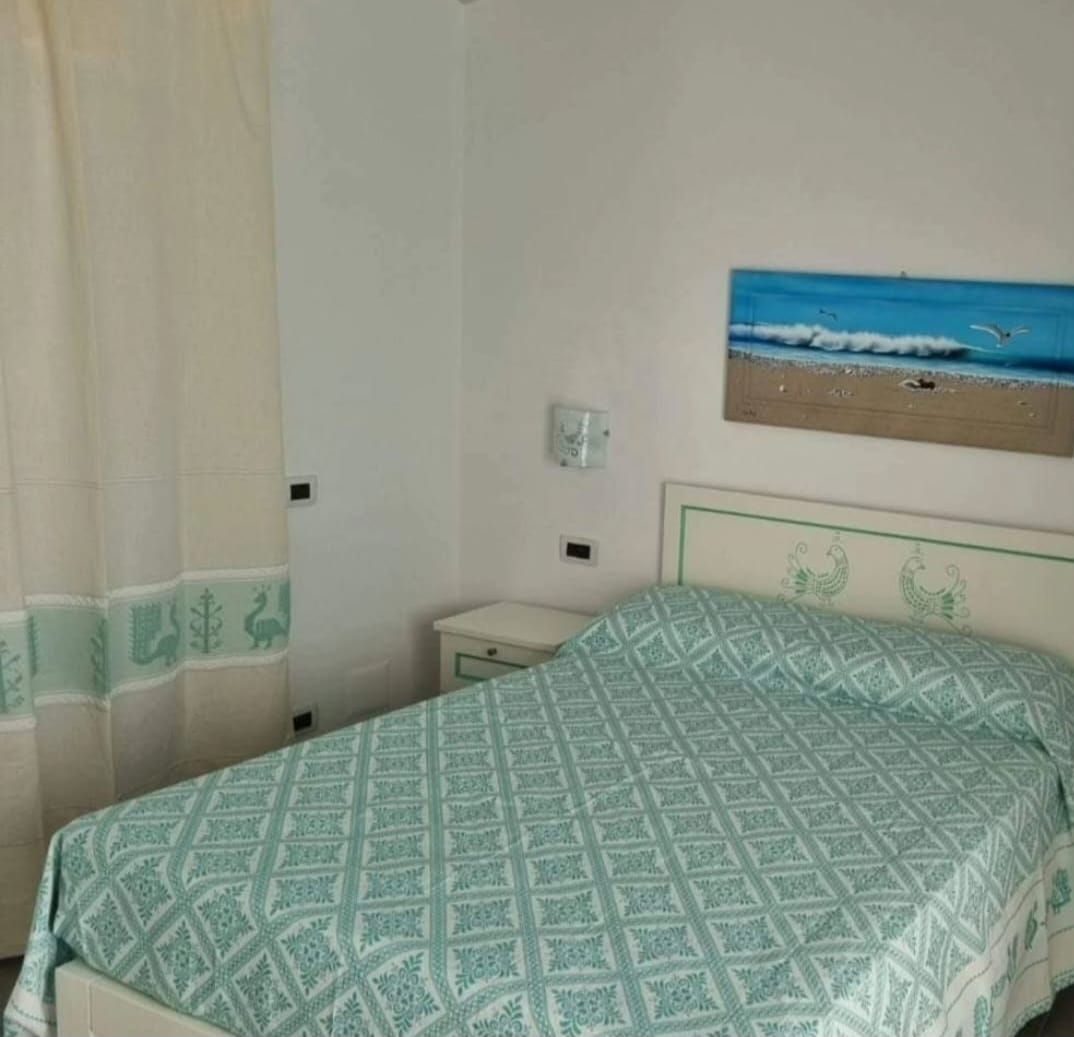 C'è una foto di una spiaggia sul muro sopra il letto.