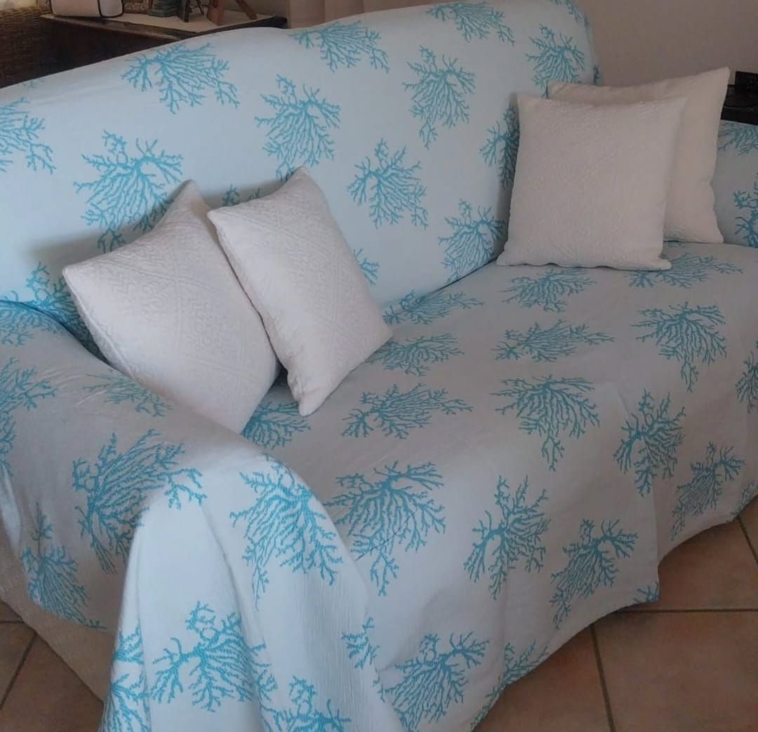 Un divano blu e bianco con cuscini bianchi sopra