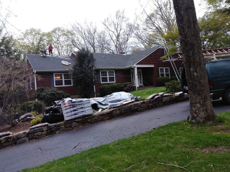 A roofer is working on the roof of a house.