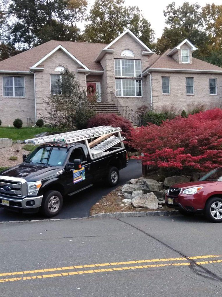A truck is parked in front of a large house