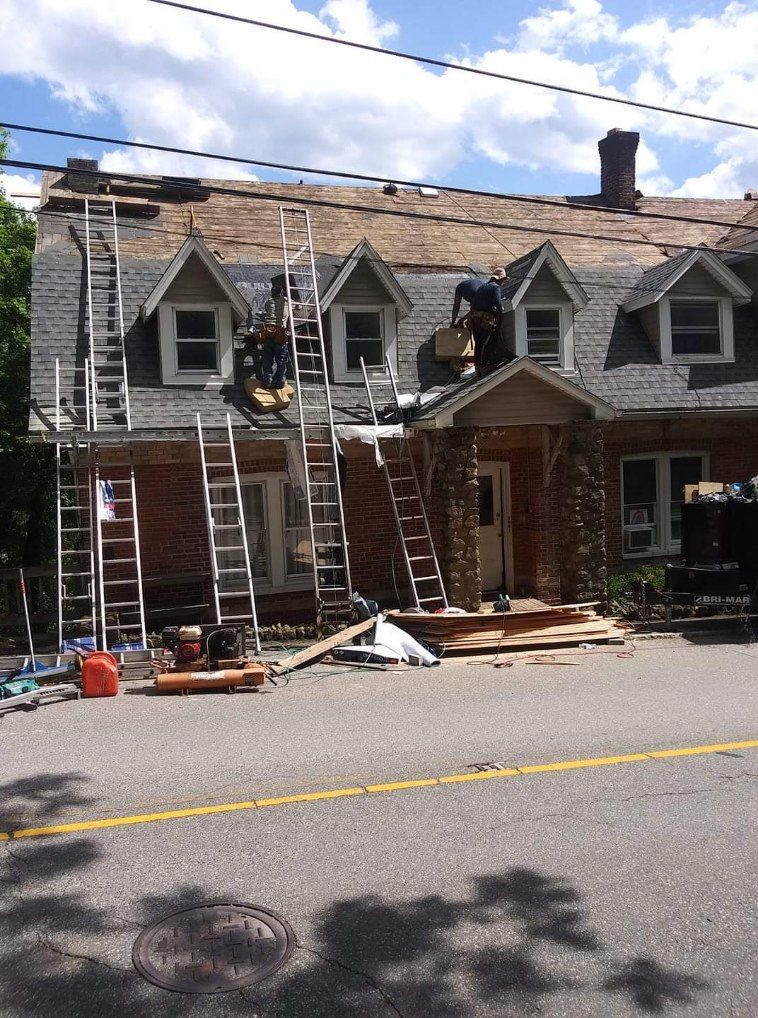 A brick house with a roof that is being repaired