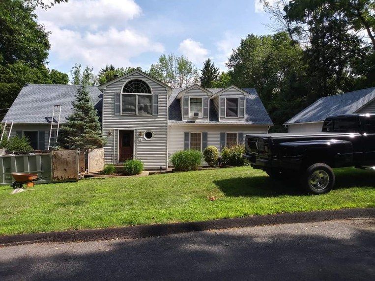 A black truck is parked in front of a house