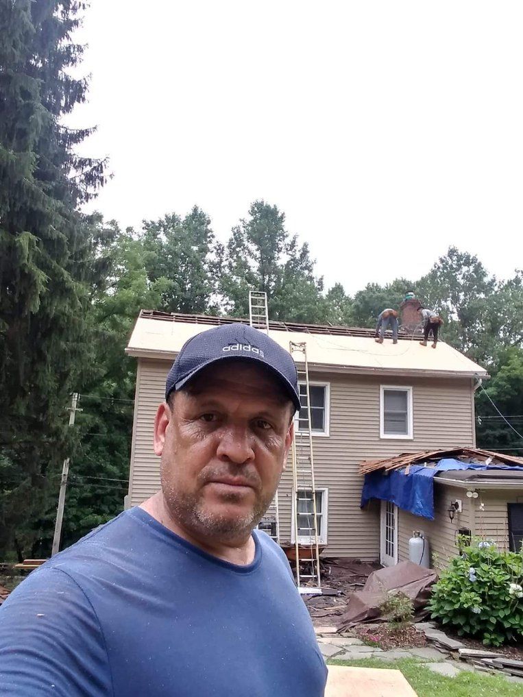 A man is standing in front of a house under construction.