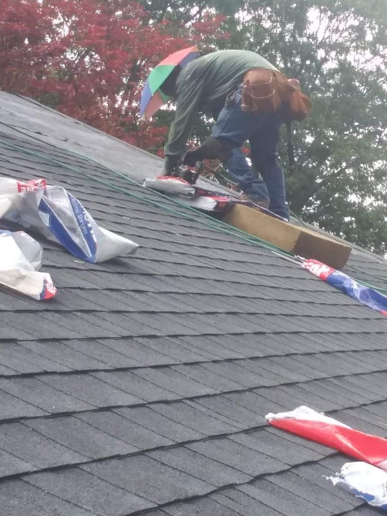 A person is working on the roof of a house